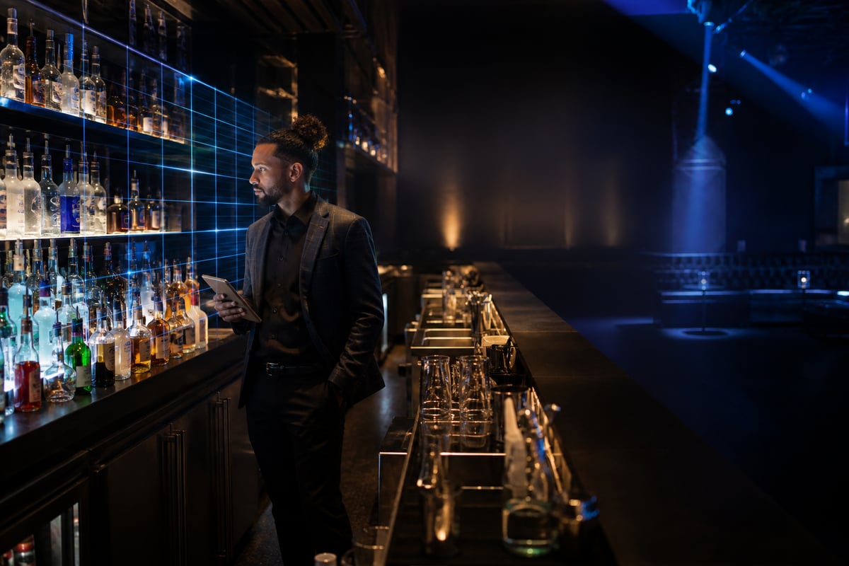 Bar manager planning nightclub event inventory across organized spirit stations