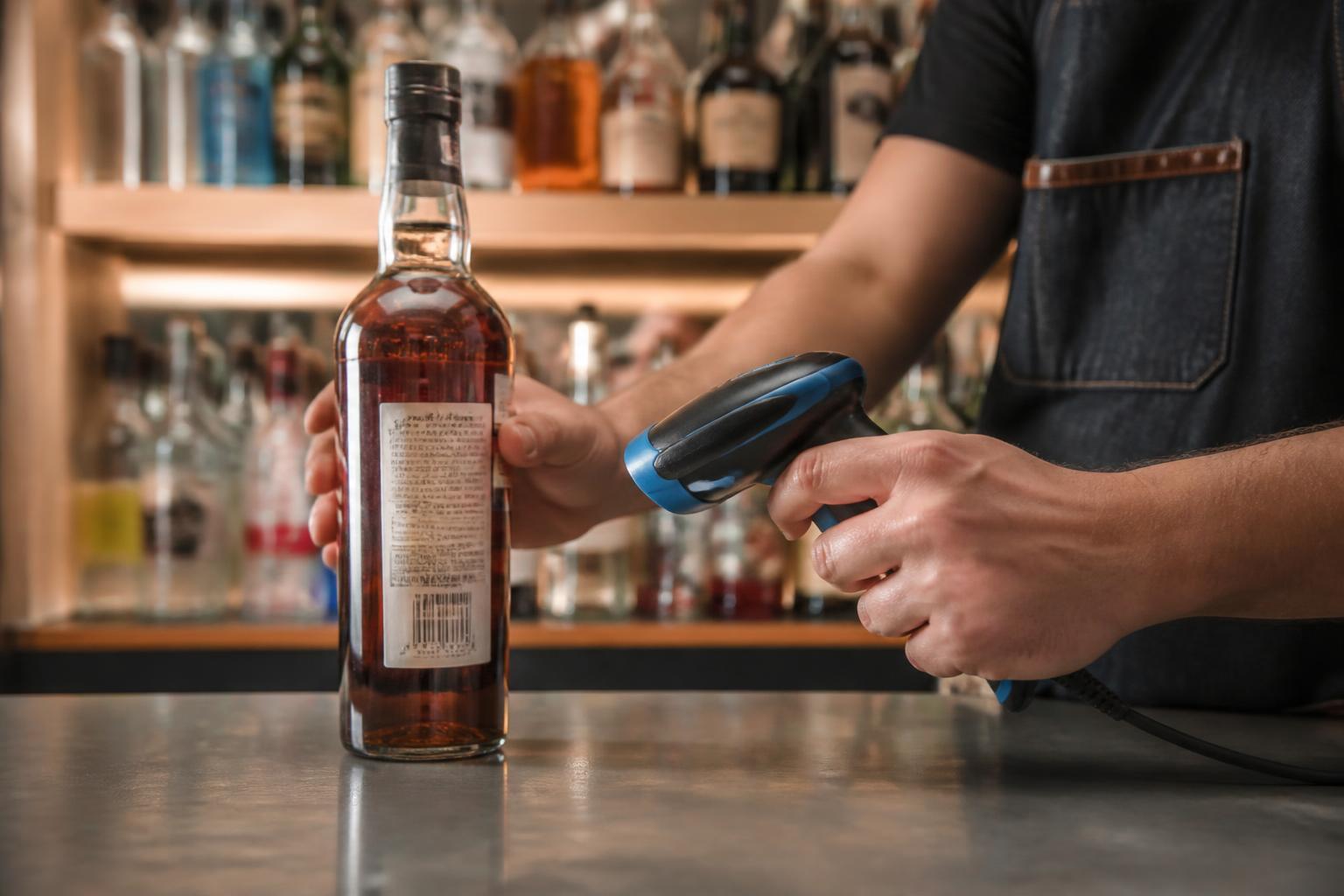 Bar employee scanning the barcode on a liquor bottle